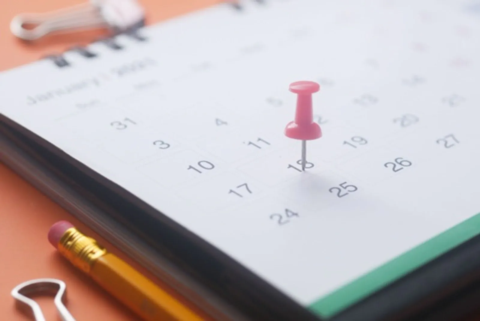 A calendar, pencil and home paperwork arranged around a closing date.