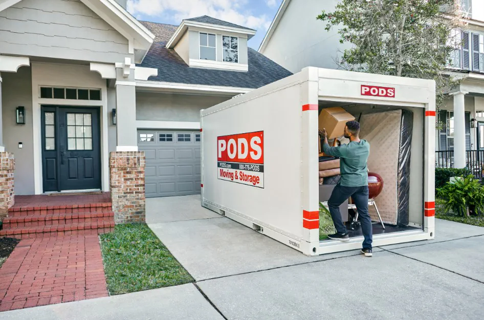 A man loads a portable storage container while moving by himself.