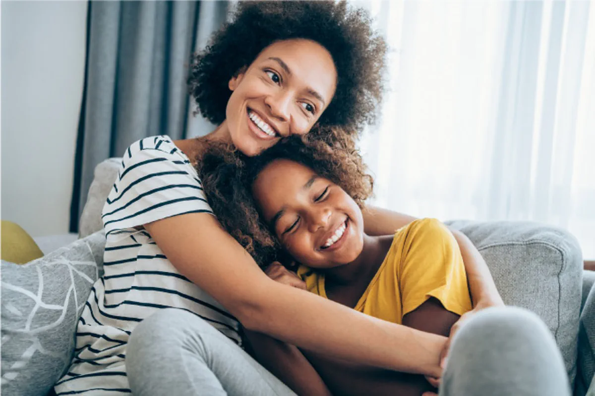 A mom and daughter smiling and embracing.
