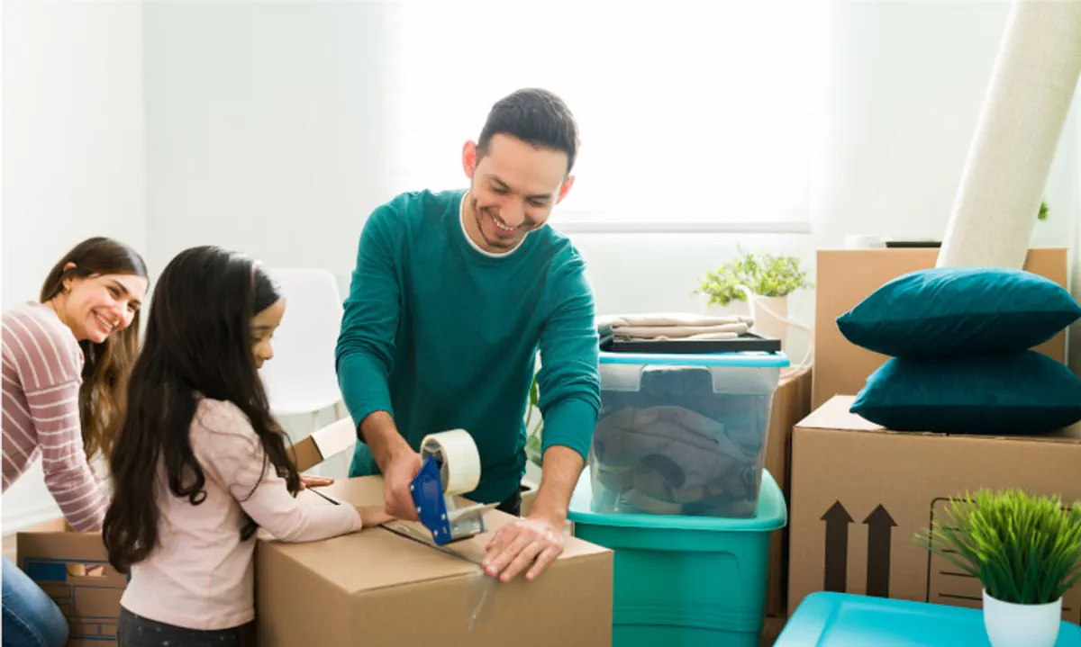 A couple who is moving with kids has their young daughter help with packing up moving boxes.