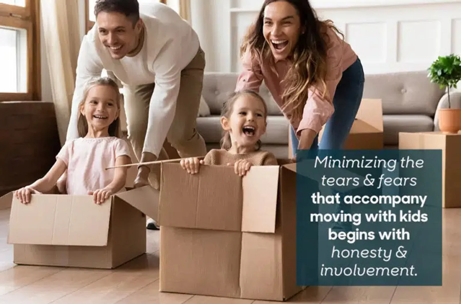 Parents and two children play among moving boxes in their home.