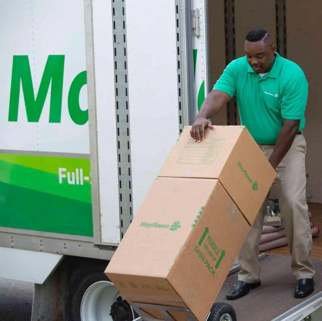 mayflower mover removing boxes from moving truck using dolly.